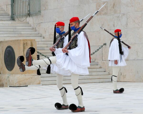 La guardia de honor de los evzones cerca de la tumba del Soldado Desconocido en la plaza Sintagma, en Atenas, durante la celebración de los 200 años del aniversario de la independencia de Grecia. - Sputnik Mundo