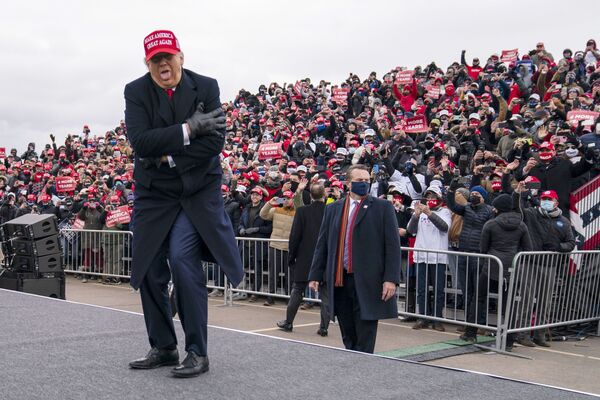 El 45 presidente de Estados Unidos, Donald Trump, bromea sobre el frío durante un encuentro con votantes en el Michigan Sports Stars Park, en Michigan, 2020.  - Sputnik Mundo