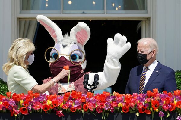 El presidente de EEUU, Joe Biden, antes de pronunciar un discurso sobre la tradición de Pascua junto con la primera dama, Jill Biden, que tiene en sus manos una flor, y una persona disfrazada de conejo de Pascua en el balcón de la habitación azul de la Casa Blanca en Washington (EEUU). - Sputnik Mundo