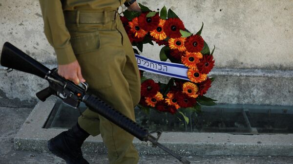 Un soldado con su arma y una corona de flores durante el Día de los Caídos, el 14 de abril de 2021 - Sputnik Mundo