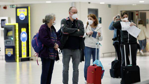 Turistas con mascarillas en un aeropuerto - Sputnik Mundo