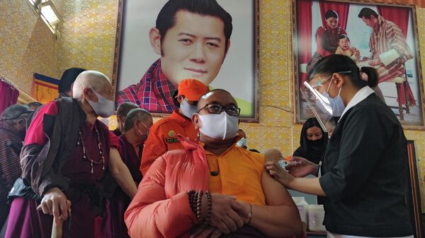 Una trabajadora de la salud vacuna a un monje budista - Sputnik Mundo