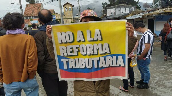 Una manifestante con un cartel contra la reforma propuesta por el Gobierno de Iván Duque - Sputnik Mundo