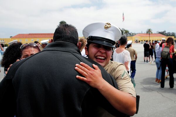 La soldado Ann Parra abraza a su padre durante la celebración del tercer batallón de la compañía Lima por convertirse en una de las primeras mujeres marines de EEUU en los 100 años de historia del Depósito de Reclutamiento del Cuerpo de Marines de San Diego (EEUU), el 6 de mayo de 2021. - Sputnik Mundo