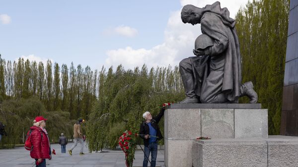 Мужчина возлагает цветы к памятнику советскому солдату на военном мемориале в Трептов-парке в Берлине в ознаменование 76-й годовщины окончания Второй мировой войны - Sputnik Mundo