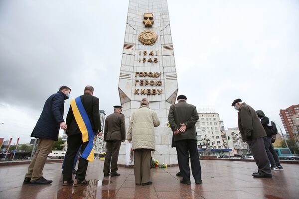 Las personas depositan flores frente al obelisco de la Ciudad Heróica de Kiev en la plaza de la Victoria de la capital ucraniana. - Sputnik Mundo