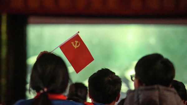 Unos estudiantes con una bandera del Partido Comunista en China - Sputnik Mundo