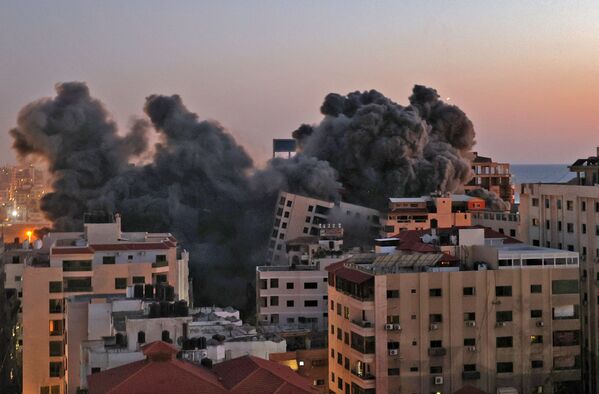 Según las Fuerzas de Defensa de Israel, desde el 10 de mayo por la noche se han disparado más de 1.000 cohetes y granadas de mortero desde la Franja de Gaza contra ciudades israelíes. Las Fuerzas de Defensa Israelí (FDI) respondieron atacando unos 500 objetivos. En la foto: los apartamentos en la Franja de Gaza que se incendiaron tras los ataques aéreos israelíes.  - Sputnik Mundo