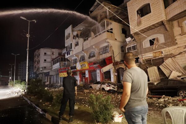 En la Franja de Gaza se reportó que los aviones israelíes bombardearon edificios gubernamentales, incluido el Ministerio del Interior. En la foto: los bomberos apagan las viviendas que se incendiaron como consecuencia de los ataques aéreos israelíes.  - Sputnik Mundo