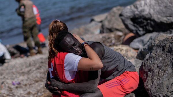 Voluntaria de la Cruz Roja abraza a un inmigrante - Sputnik Mundo