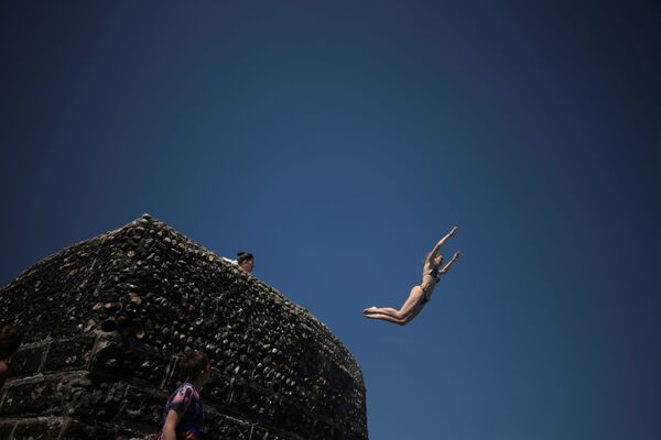 Una persona salta al mar en la playa de Brighton (Reino Unido). - Sputnik Mundo
