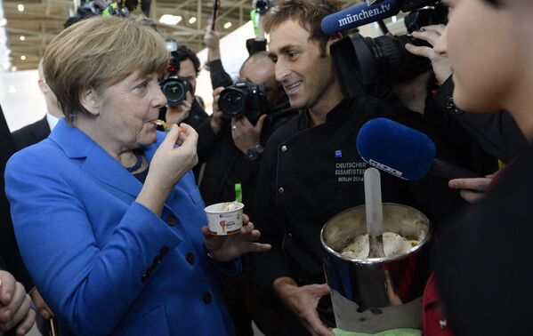La canciller alemana, Angela Merkel, se come un helado mientras asiste a la feria Internationale Handwerksmesse en Munich (Alemania), en 2015. - Sputnik Mundo