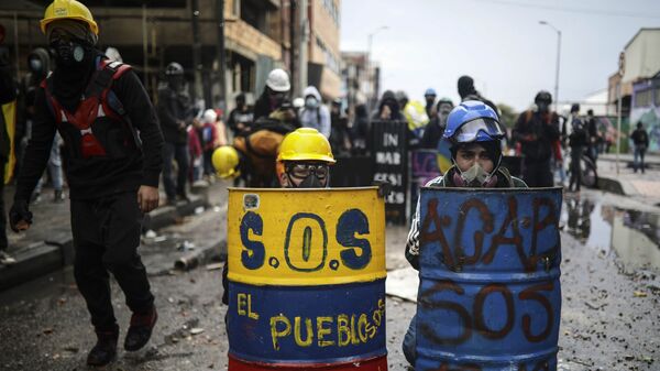 Антиправительственные протестующие прячутся за импровизированными щитами во время столкновений с полицией в Боготе, Колумбия - Sputnik Mundo