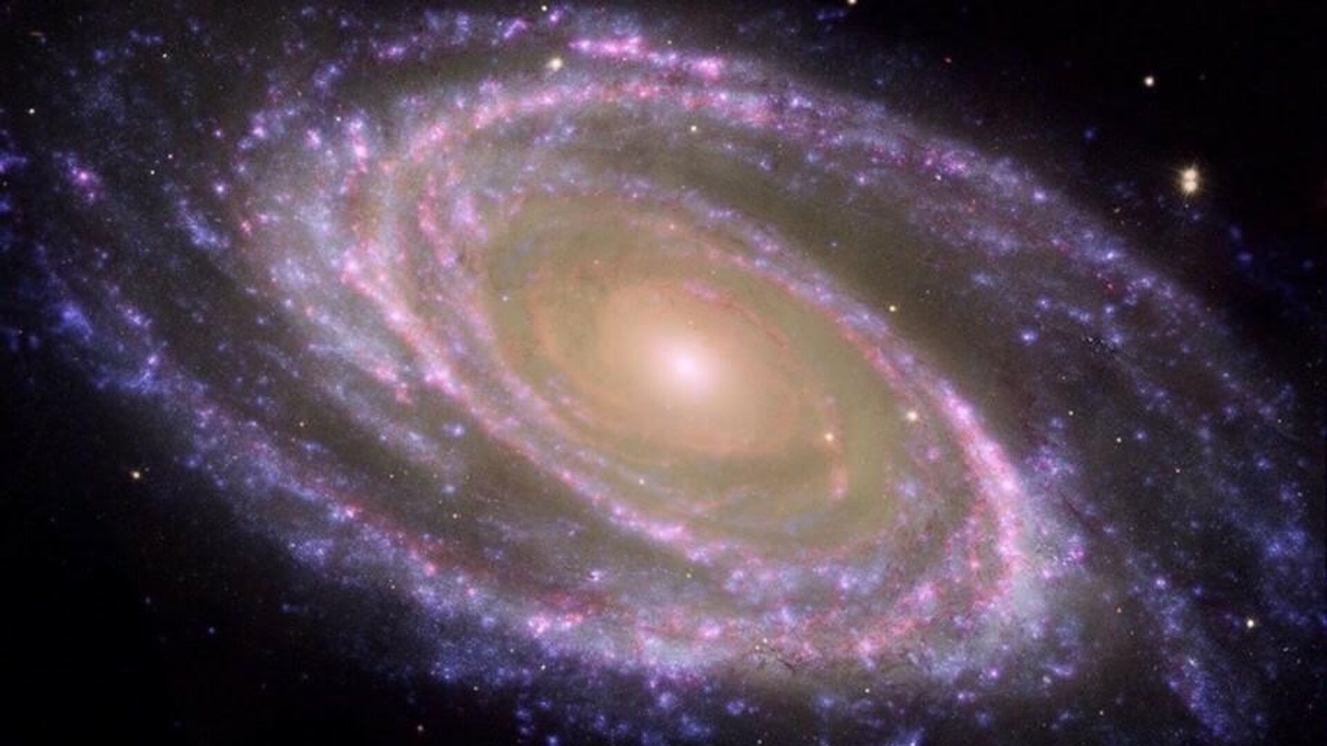 Esto es una galaxia espiral cercana, la M81, en el centro está el bulbo (rojizo) y el exterior (azulado) los brazos espirales, donde se crean las estrellas - Sputnik Mundo, 1920, 30.01.2022