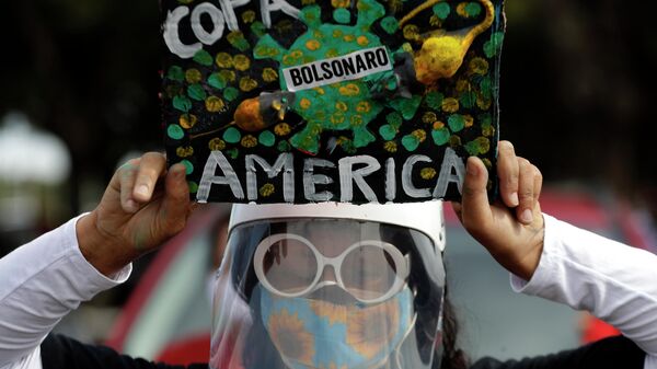 Una mujer con mascarilla protesta contra la realización de la Copa América en Brasil en plena pandemia de COVID-19 - Sputnik Mundo
