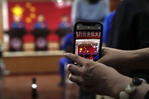 Un periodista fotografía a los taikonautas chinos durante una rueda de prensa en Jiuquan. - Sputnik Mundo