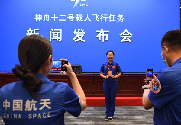 Los empleados del Jiuquan Satellite Launch Center se hacen fotos antes de la rueda de prensa. - Sputnik Mundo