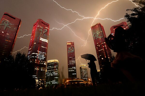 Un rayo atraviesa el cielo durante un espectáculo de luces en Pekín. - Sputnik Mundo