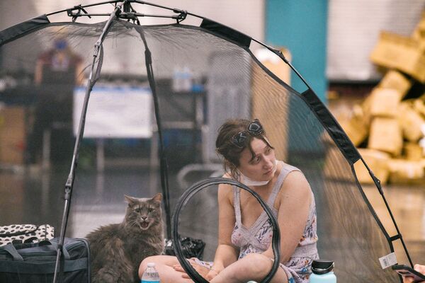 Una mujer y su gato se cobijan de la ola de calor en el Centro de Convenciones de Portland, en Estados Unidos. - Sputnik Mundo