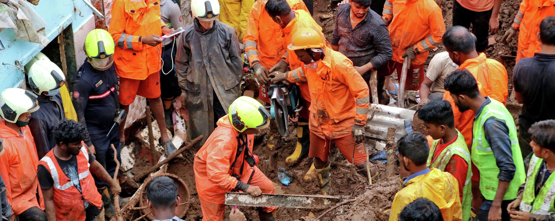 Los trabajadores de rescate retiran escombros mientras buscan sobrevivientes después de que una casa colapsara debido al deslizamiento de tierra causado por fuertes lluvias en Bombay, la India, el 18 de julio - Sputnik Mundo, 1920, 18.07.2021