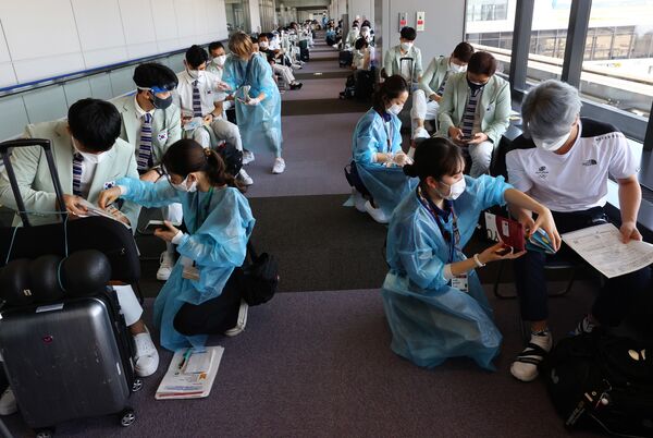 En las últimas 24 horas en Tokio se detectaron 1.410 contagios. Es la mayor cifra desde enero de 2021. Entre los deportistas, ya se registraron algunos casos de COVID-19. En la foto: los miembros de la selección olímpica surcoreana se someten a la prueba por coronavirus en el aeropuerto de Narita. - Sputnik Mundo