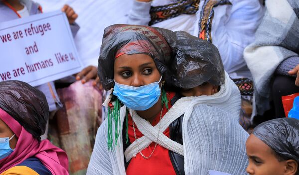 Unos refugiados eritreos protestan frente a las oficinas del Alto Comisionado de las Naciones Unidas para los Refugiados (ACNUR) en Adís Abeba (Etiopía) para condenar los ataques contra los campamentos de Hitsats y Shimelba. - Sputnik Mundo