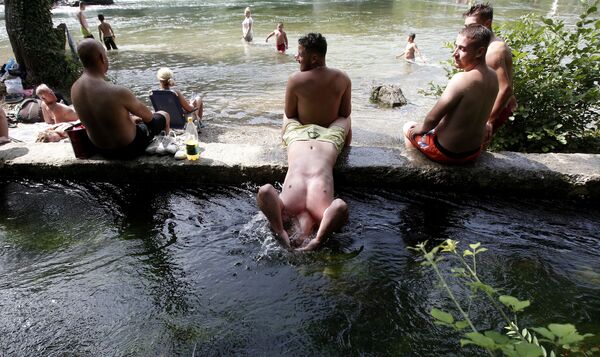 Un hombre sumerge la cabeza en el río Treska, al oeste de Skopje (Macedonia del Norte), en un día de calor extremo. - Sputnik Mundo