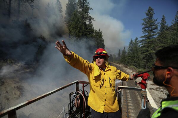 Más de 19.000 bomberos y personal de apoyo están trabajando para evitar la propagación del fuego. En la foto: los bomberos de Union Pacific coordinan su trabajo para apagar las llamas en California. - Sputnik Mundo