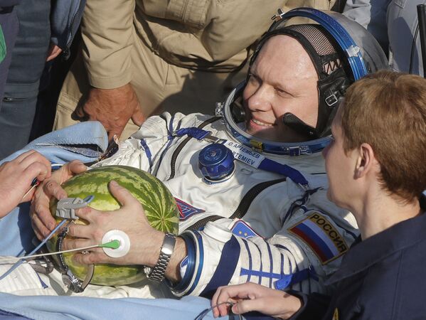 El cosmonauta ruso Oleg Artemiev sujeta una sandía tras el aterrizaje de la nave espacial Soyuz TMA-12M en la estepa kazaja.  - Sputnik Mundo