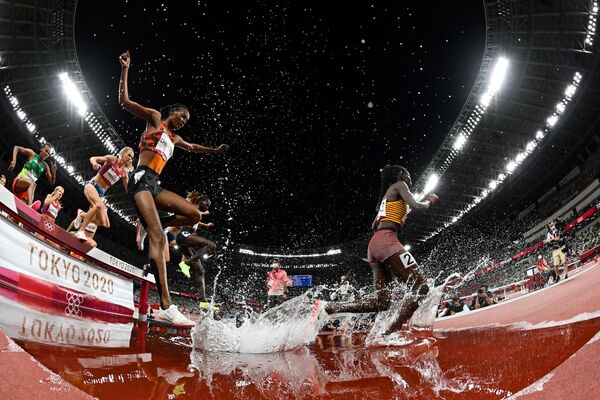 Los atletas compiten en la final de los 3.000 metros obstáculos femeninos durante los Juegos Olímpicos de Tokio 2020. - Sputnik Mundo