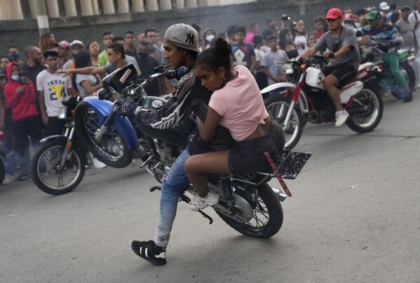 Un motociclista realiza una acrobacia en su moto durante una exhibición en el barrio El Valle de Caracas, Venezuela. - Sputnik Mundo
