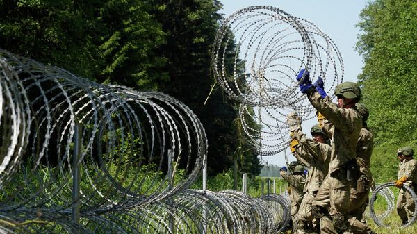 Militares de Letonia instalan alambre de púa en la forntera con Bielorrusia para prevenir el flujo de migrantes - Sputnik Mundo