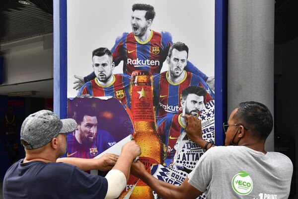 Los trabajadores del estadio Camp Nou de Barcelona retiran carteles que muestran al alero argentino Lionel Messi, quien firmó con el PSG - Sputnik Mundo