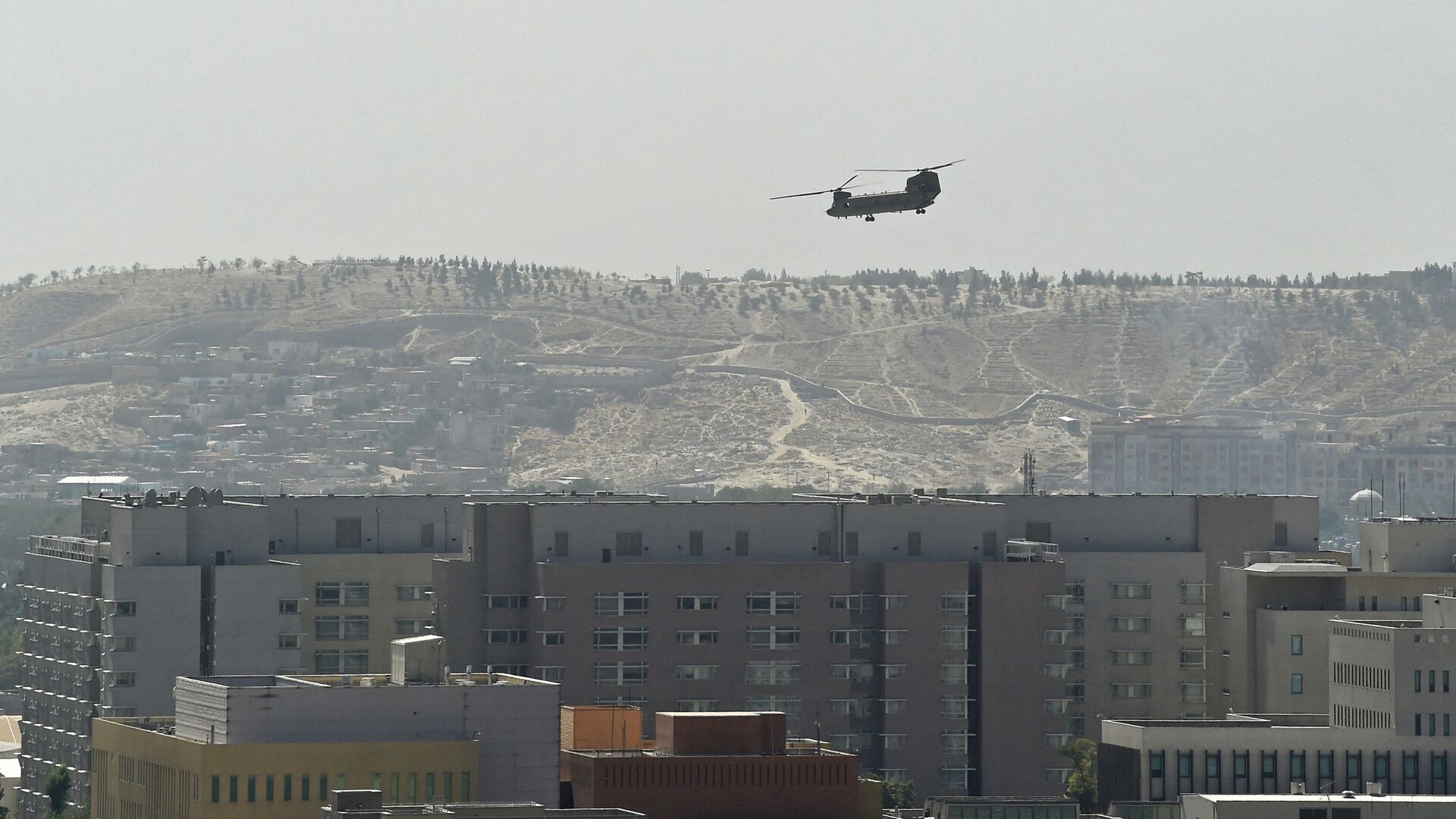 Un helicóptero militar estadounidense volando sobre la embajada de Estados Unidos en Kabul el 15 de agosto de 2021 - Sputnik Mundo, 1920, 16.08.2021