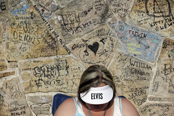 Actualmente, se llevan a cabo negociaciones con la exesposa del músico, Priscilla Presley, para la creación de un espectáculo completo de hologramas de Elvis en Las Vegas (EEUU).En la foto: una fan de Elvis Presley espera en una fila frente a Graceland, la casa del cantante en Memphis, el 15 de agosto de 2012 para participar en la vigilia anual a la luz de las velas con motivo del 35 aniversario de la muerte del artista. - Sputnik Mundo