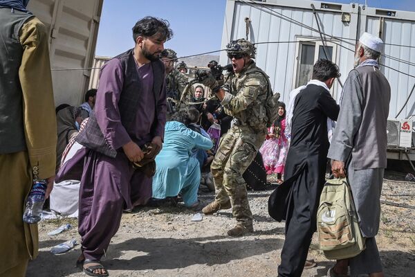 Un soldado estadounidense apunta a un afgano en el aeropuerto de Kabul, el 16 de agosto de 2021. El presidente afgano, Ashraf Ghani, dimitió y huyó del país el 15 de agosto. - Sputnik Mundo