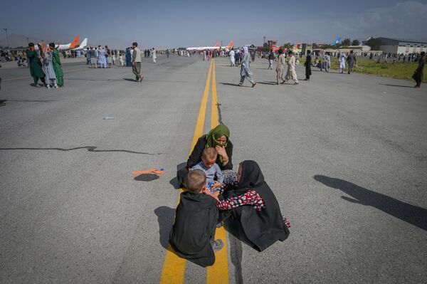 La pista de aterrizaje del aeropuerto internacional de Kabul. La gente espera para abandonar el país después de 20 años de guerra en Afganistán. - Sputnik Mundo