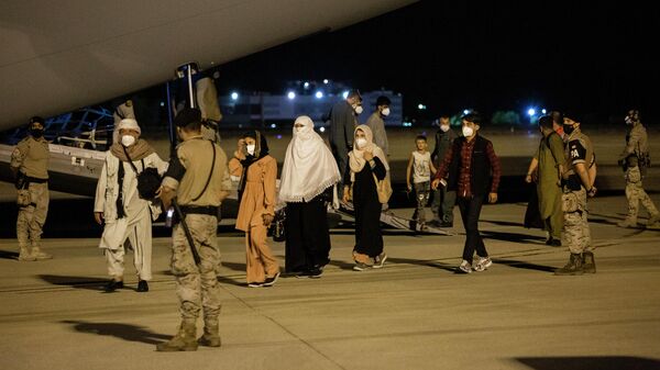 Varias personas repatriadas llegan a la pista tras bajarse del avión A400M en el que ha sido evacuados de Kabul, a 19 de agosto de 2021, en Torrejón de Ardoz, Madrid - Sputnik Mundo
