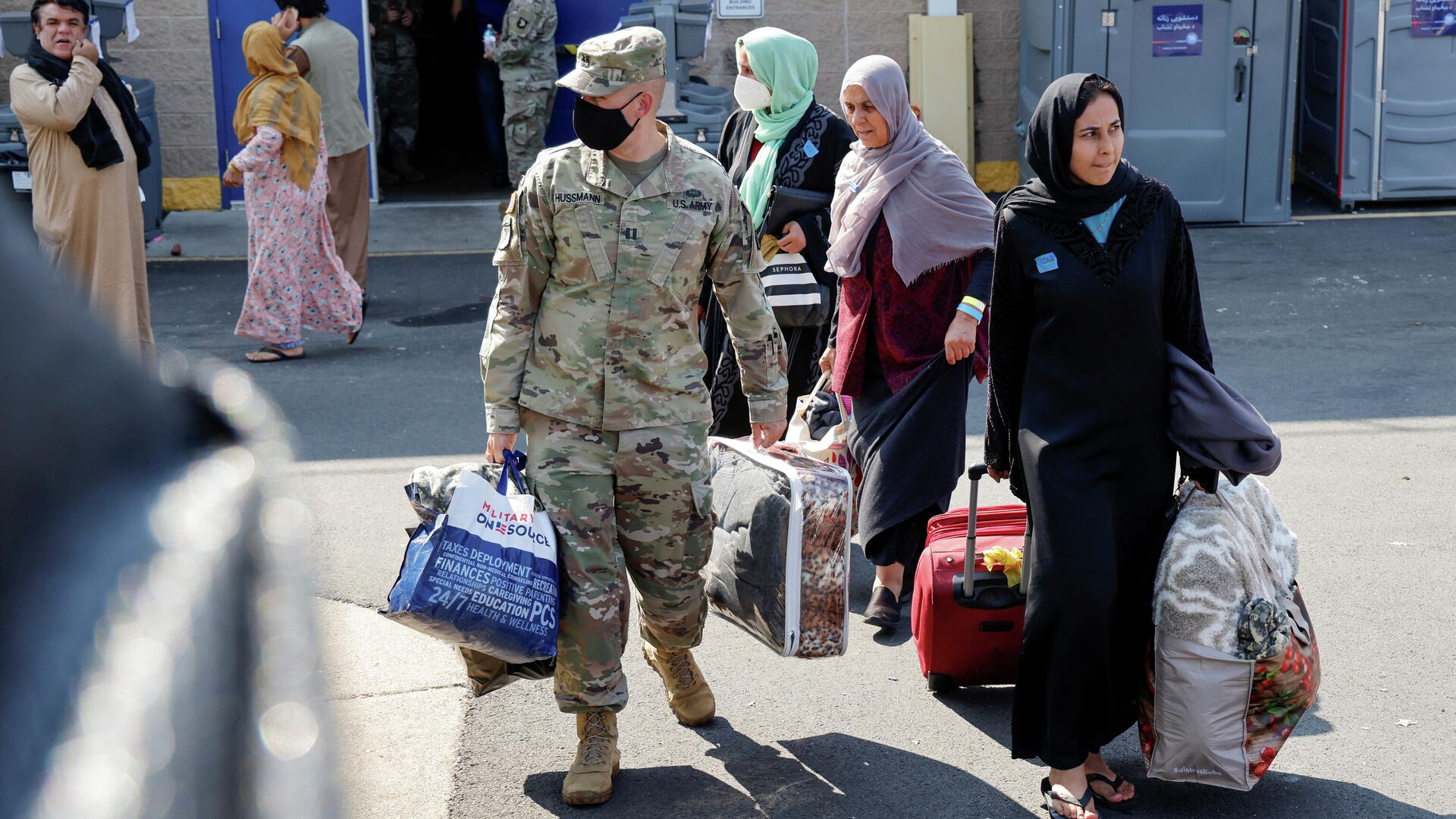 Los militares estadounidenses ayudan a las familias cuando salen de un centro para evacuados de Afganistán en el Dulles Expo Center cerca del Aeropuerto Internacional de Dulles en Chantilly, Virginia, EEUU, 25 de agosto de 2021 - Sputnik Mundo, 1920, 26.08.2021