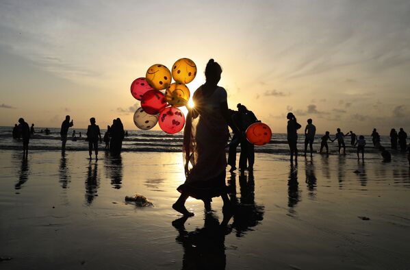 Una mujer vende globos en una playa de Bombay (India). - Sputnik Mundo