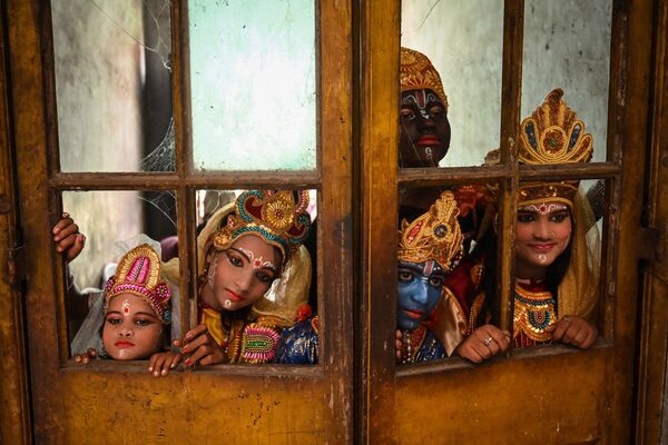 Artistas vestidas del dios hindú Krishna y sus compañeros mitológicos antes de actuar en el festival Janmashtami para conmemorar el nacimiento del Krishna en Calcuta, el 30 de agosto de 2021. - Sputnik Mundo