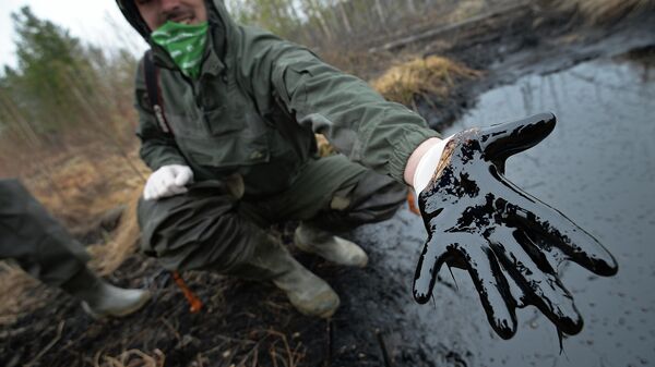 Un hombre muestra las consecuencias de un derrame de petróleo en Rusia - Sputnik Mundo