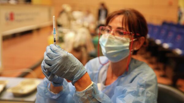 Una sanitaria prepara una vacuna contra el coronavirus - Sputnik Mundo