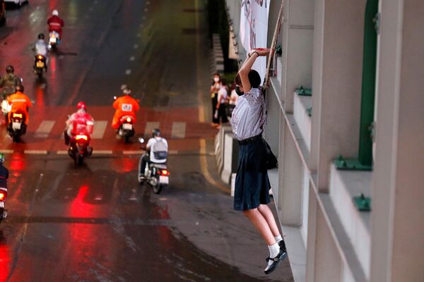 Una manifestante finge ahorcarse en una acción de protesta contra las medidas pandémicas en Tailandia. - Sputnik Mundo