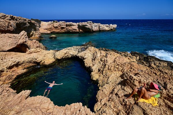 Unos turistas disfrutan del mar en la isla de Koufonissi, en el mar Egeo. - Sputnik Mundo