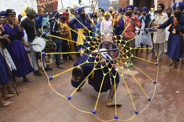 Un sij muestra un truco de arte marcial tradicional Gatka en el Templo Dorado de Amritsar, en la India. - Sputnik Mundo