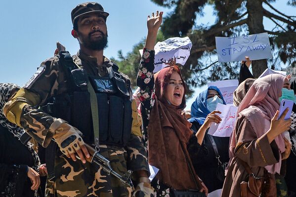 Unas mujeres afganas junto a un militante talibán* durante una protesta frente a la embajada de Pakistán en Kabul. Los talibanes dispararon al aire para disipar la manifestación. - Sputnik Mundo