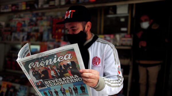 Un hombre lee un periódico con los resultados de las elecciones primarias en Argentina - Sputnik Mundo