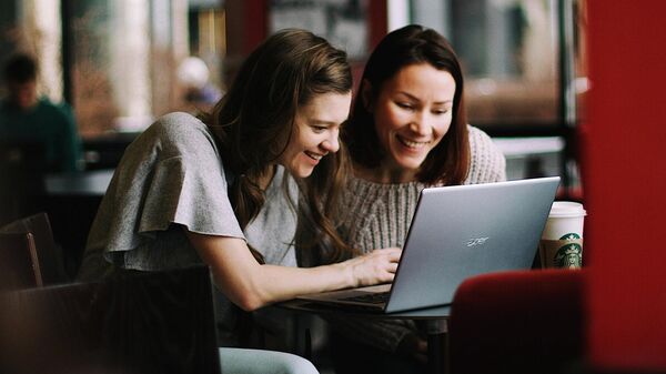 Unas jóvenes usan un ordenador portátil - Sputnik Mundo