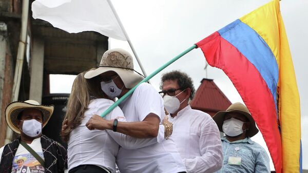 Rodrigo Granda, integrante del partido político FARC y excombatiente, se abraza con la familia de una víctima de la guerrilla en 2020 - Sputnik Mundo
